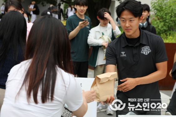 8일 아주대 학생회관 앞에서 열린 찾아가는 사랑의 밥차 ‘청년들 힘내세요’ 무료 급식 행사에 참여한 수원FC 이승우 선수가 한 대학생에게 햄버거와 음료수를 건네고 있다.