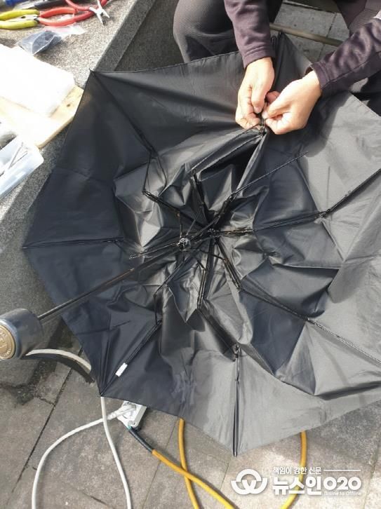 고장 난 우산을 수리하는 모습