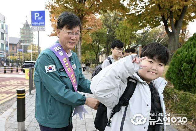 이민근 안산시장(사진 왼쪽)이 학현초등학교 앞에서 ‘스쿨존 어린이 교통안전 캠페인’을 진행하며 등교하는 어린이의 가방에 '홍이 키링'을 달아주고 있다.