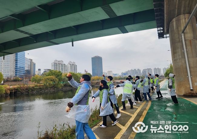 서울물재생시설공단‧환경실천연합회 직원들과 시민들이 친환경 정화 물질인 EM 흙공을 안양천에 던지고 있다.